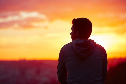 Homme devant un coucher de soleil en hiver